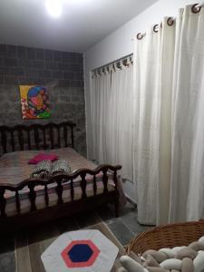 a bedroom with a bed and curtains in a room at Apartamento para casal em São Lourenço in São Lourenço