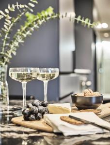 a table with two glasses of wine and grapes at Melbourne City Apartment Hotel in Melbourne