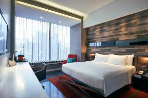 um quarto de hotel com uma cama e uma grande janela em Quincy Hotel Singapore by Far East Hospitality em Singapura