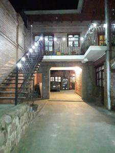Vaqueros的住宿－Alojamiento Los Amigos，一座有楼梯的建筑和一个有车的停车场
