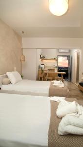 a hotel room with two beds and a table at Horizon Hotel Kalymnos in Myrties