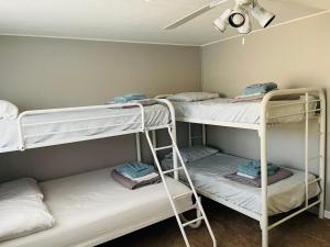 a room with three bunk beds and a ceiling at Charming Cottage with Fenced Backyard Pet Friendly in Rehoboth Beach