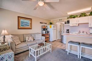 a living room with a couch and a kitchen at Isle of Palms Beachfront Condo with Balcony and Pool! in Isle of Palms