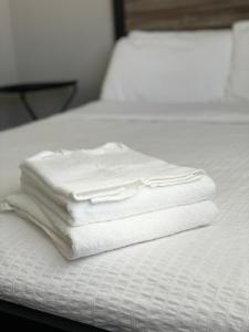 a stack of white towels sitting on top of a bed at Charming Cottage with Fenced Backyard Pet Friendly in Rehoboth Beach