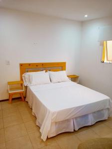 een slaapkamer met een groot wit bed in een kamer bij Hotel Atlantis in San Bernardo