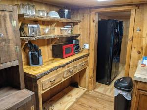 eine Küche mit einer Theke, einer Mikrowelle und einem Kühlschrank in der Unterkunft Woodard Cabin in Cullowhee