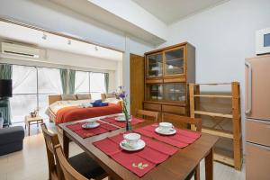 a living room with a table and a bed at G&R House 102 in Tokyo