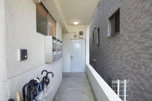 a hallway leading to a door in a building at G&R House 102 in Tokyo