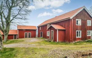 un granero rojo con dos edificios en un patio en Cozy Home In deshg With Kitchen, en Ödeshög