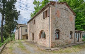 un ancien bâtiment en briques situé sur le côté d'une route dans l'établissement 6 Bedroom Gorgeous Home In Montaione, à Montaione