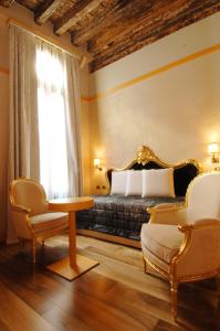 1 dormitorio con 1 cama, mesa y sillas en Hotel Cà Zusto Venezia, en Venecia