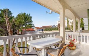 a white table and chairs on a balcony at Beautiful Apartment In Barbat Na Rabu With Outdoor Swimming Pool in Barbat na Rabu
