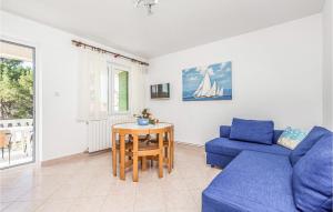 a living room with a blue couch and a table at Beautiful Apartment In Barbat Na Rabu With Outdoor Swimming Pool in Barbat na Rabu