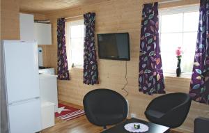 een woonkamer met 2 stoelen en een televisie bij Cozy Apartment In Sandstad With Wifi in Skipnes