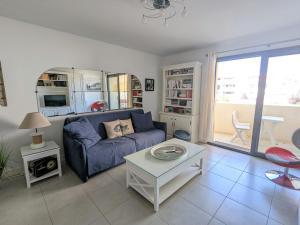 uma sala de estar com um sofá azul e uma mesa em Appartement Arcachon, 2 pièces, 2 personnes - FR-1-420-90 em Arcachon