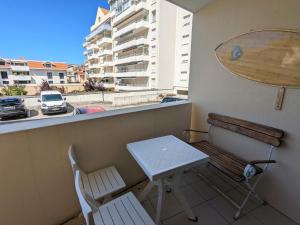 a small table and chairs on a balcony with a view of a city at Appartement Arcachon, 2 pièces, 2 personnes - FR-1-420-90 in Arcachon
