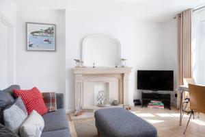 a living room with a couch and a fireplace at Lower Fernlea in Salcombe
