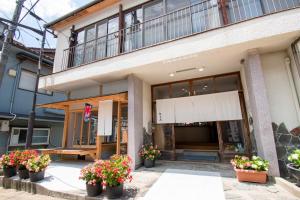 長門的住宿－Guesthouse Neruyama，前面有盆栽植物的建筑