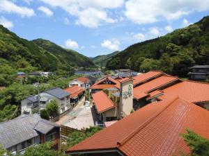 una ciudad con techos naranjas y montañas de fondo en Guesthouse Neruyama, en Nagato