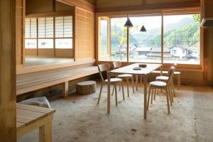 comedor con mesa, sillas y ventana en 日貫一日　安田邸, en Ohnan-cho