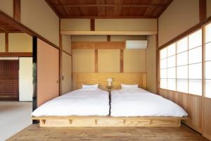 日貫一日　安田邸 في Ohnan-cho: غرفة نوم بسرير ذو شراشف بيضاء