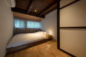 una camera da letto con un letto con lenzuola bianche e una finestra di 日貫一日　安田邸 a Ohnan-cho