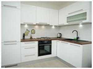 Una cocina blanca con gabinetes blancos y un fregadero. en House Natalija, en Primošten 29 fotos más