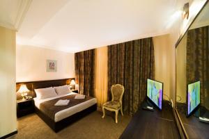 Habitación de hotel con cama y TV en Kalasi Hotel, en Tiflis