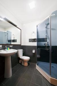y baño con aseo, lavabo y ducha. en Kalasi Hotel, en Tiflis