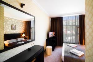 a hotel room with a large bed and a large window at Kalasi Hotel in Tbilisi City