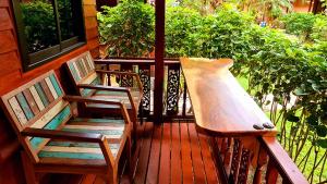 two chairs sitting on a porch next to a window at Longtail Beach Resort in Thong Nai Pan Yai