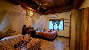 a bedroom with two beds and a ceiling fan at Longtail Beach Resort in Thong Nai Pan Yai