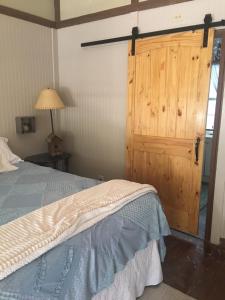 a bedroom with a bed and a wooden door at Acorn Hideaways Canton Sweet Tweet Guesthouse King Bed in Canton