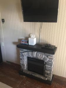 een open haard met een televisie erop bij Acorn Hideaways Canton Sweet Tweet Guesthouse King Bed in Canton +5 foto's