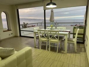 a dining room with a table and chairs on a balcony at HERMOSO APARTAMENTO CON TERRAZA Y VISTA AL MAR in Viña del Mar