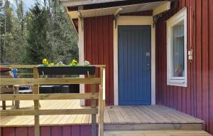 a house with a blue door and a wooden deck at Holiday Home Nyttorp Högsby in Hultsnäs