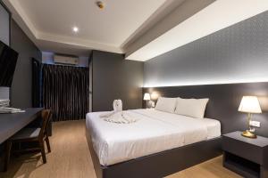 Habitación de hotel con cama, escritorio y cama sidx sidx en Siam Star Hotel en Bangkok