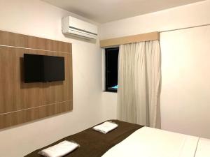 a bedroom with a bed and a flat screen tv at Biarritz temporadalitoranea in São Luís