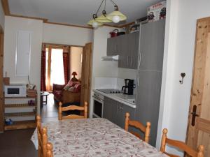 kuchnia i jadalnia ze stołem oraz kuchnia gmaxwell gmaxwell gmaxwell w obiekcie Appartement familial avec parking et proche des pistes - FR-1-464-201 w mieście Pralognan-la-Vanoise