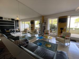 ein Wohnzimmer mit Couch, Stühlen und Tischen in der Unterkunft Studio moderne avec terrasse vue plage et parking à Arcachon - FR-1-474-205 in Arcachon + 8 Fotos