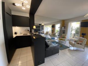 eine Küche und ein Wohnzimmer mit einer Couch und einem Tisch in der Unterkunft Studio moderne avec terrasse vue plage et parking à Arcachon - FR-1-474-205 in Arcachon