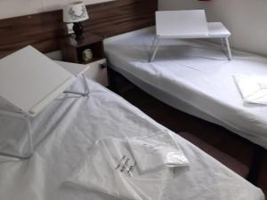 2 camas con sábanas blancas y ordenador portátil en la parte superior en Chalet Dolus-d'Oléron, 3 pièces, 4 personnes - FR-1-246A-120, en Dolus d'Oléron