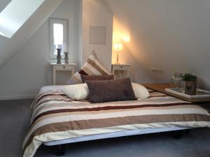 a bedroom with a large bed with a striped blanket at Landhaus Moselschön in Alken