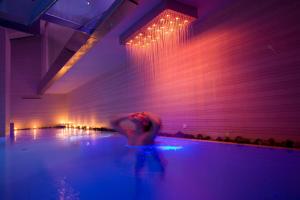 una persona en una piscina con luces azules y rojas en Residence Eden & Spa, en Gabicce Mare