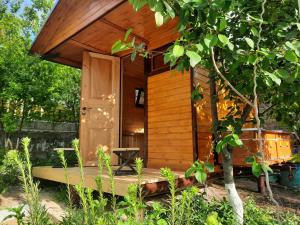 a wooden cabin with a porch in a garden at Guest House LEADER in Ijevan