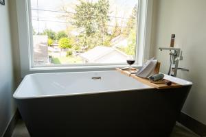 a bath tub in a room with a window at Amorcito de Jenny - Shared House in Portland