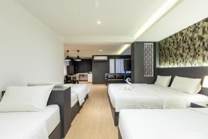 1 dormitorio con 3 camas y sala de estar en Siam Star Hotel en Bangkok