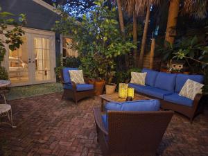 un patio con un sofá azul, sillas y una mesa en Chateau Gardens, en Lake Worth