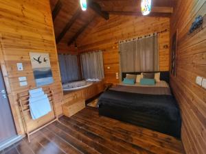 1 dormitorio en una cabaña de madera con cama y bañera en A Place To Dream en Ẕippori