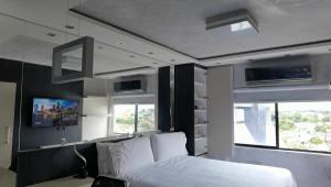 1 dormitorio con 1 cama blanca y 2 ventanas en Flat Apartamento ALTÍSSIMO NÍVEL Último Andar en Teresina
